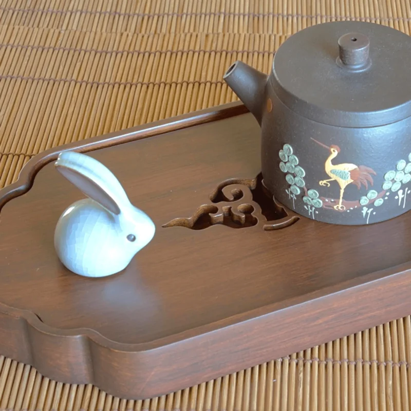 Arbatos ceremonija ant Chaban padėklo su moliniu arbatinuku ir dekoratyvine triušio figūrėle