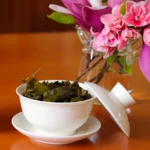 TS-B6021498-02 Atidaryta Gaivanis su užplikytais arbatos lapeliais ir gėlėmis fone