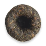 Tamsiai žali brandinti Sheng Pu-erh arbatos lapeliai supresuoti į lizdą