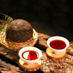Tamsiai raudonas brandintos Pu-erh arbatos užpilas baltuose puodeliuose