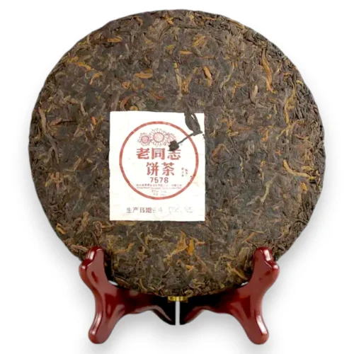 Išpakuotas 357g Haiwan Pu-erh arbatos blynas ant medinio stovo