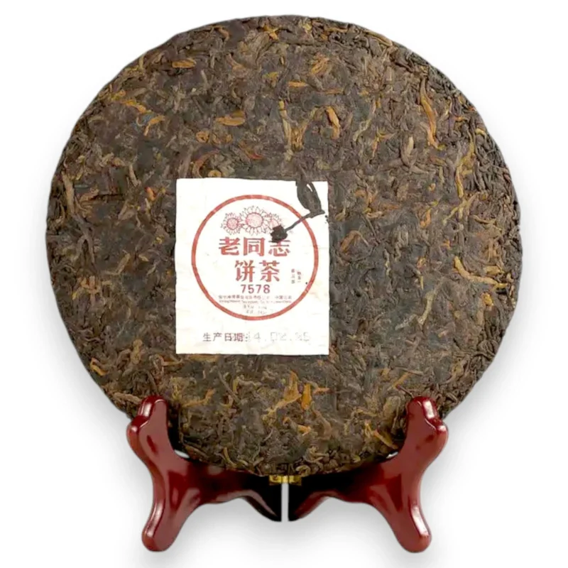 Išpakuotas 357g Haiwan Pu-erh arbatos blynas ant medinio stovo