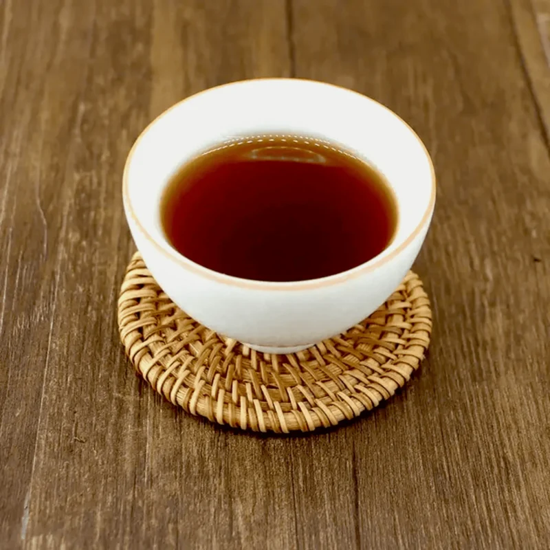 Tamsiai raudonas Shou Pu-erh arbatos užpilas baltame porceliano puodelyje