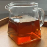 Da-Hong-Pao-arbatos-antpilas-spalva Skaidrus, gintaro spalvos Da Hong Pao arbatos antpilas stikliniame ąsotėlyje (Gong Dao Bei)